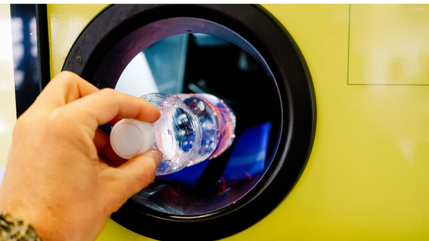 sticla de plastic introdusa intr-un automat de reciclare din sistemul de garantie retrunare